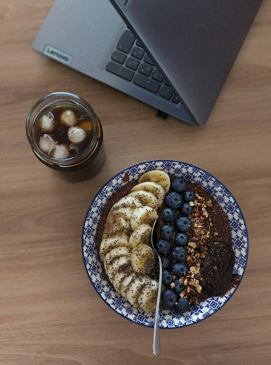 Overhead view of a desk with a laptop, notebook and coffee cup